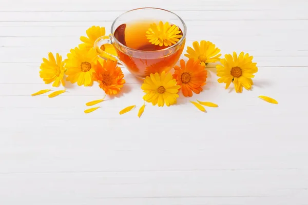Calendula (Marigold) herbal tea  on white wooden table — Stock Photo, Image