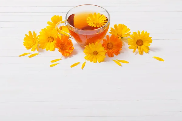 Calendula (Goudsbloem) kruidenthee op witte houten tafel — Stockfoto