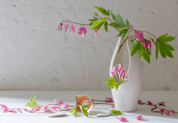 pink flowers in vase on old white background