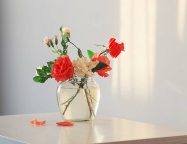 Beyaz arka plan üzerinde cam vazoda gül