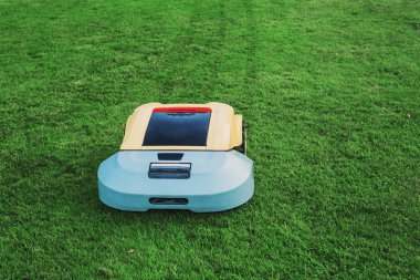 Robot çim biçme makinesi arka plan yeşil çimenlerin üzerinde