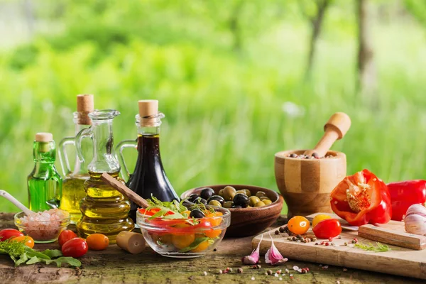 Verdure con olio su tavolo di legno esterno — Foto Stock