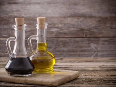 Zeytinyağı ve ahşap arka plan üzerinde balsamik sirke