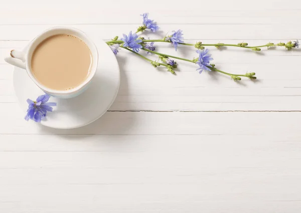 Boire de la chicorée dans une tasse sur la table en bois blanc — Photo