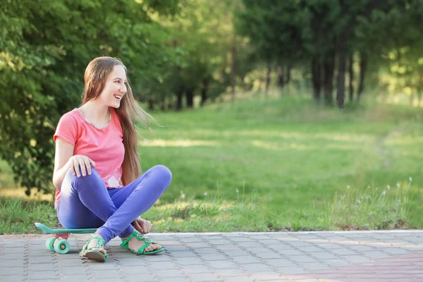 夏の公園でスケート ボードを持つ十代の女の子 — ストック写真
