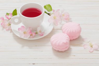 Çiçekli Beyaz ahşap zemin üzerinde kırmızı çay