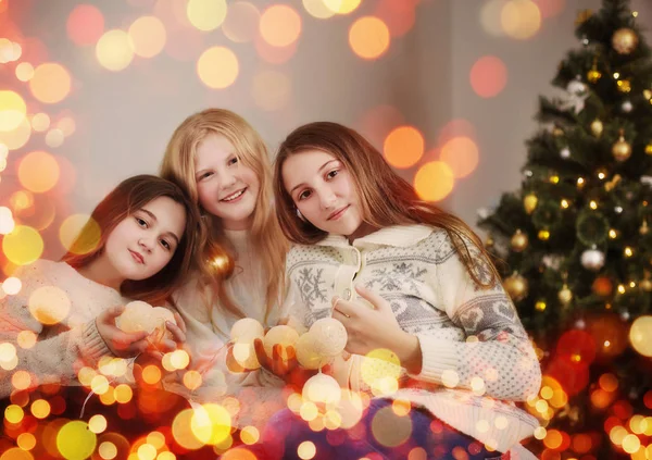 Três meninas em uma árvore de Natal — Fotografia de Stock