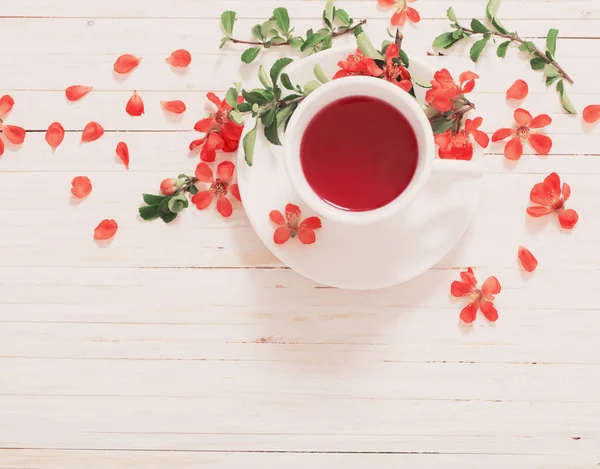 Çiçekli Beyaz ahşap zemin üzerinde kırmızı çay — Stok fotoğraf
