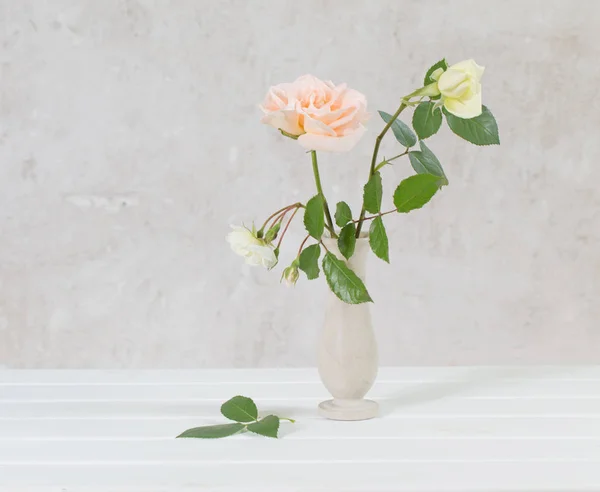 Róże w wazonie na starym białym tle — Zdjęcie stockowe