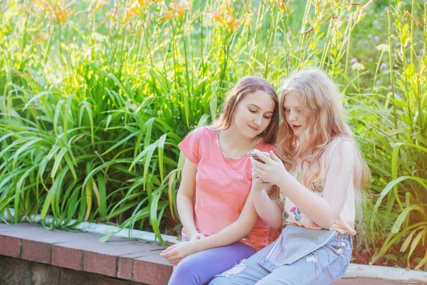 Две девочки-подростка с телефоном на улице — стоковое фото