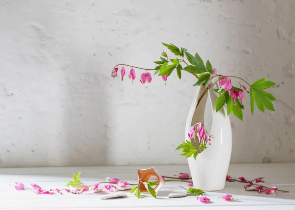 Розовые цветы в вазе на старом белом фоне — стоковое фото