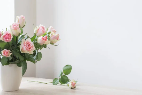 Różowe róże w wazonie na białym tle — Zdjęcie stockowe