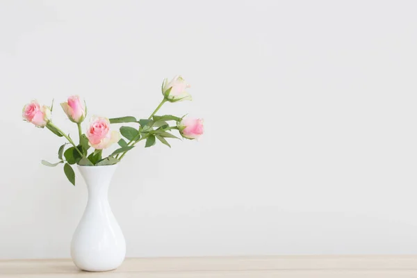 Rosas cor de rosa em vaso sobre fundo branco — Fotografia de Stock