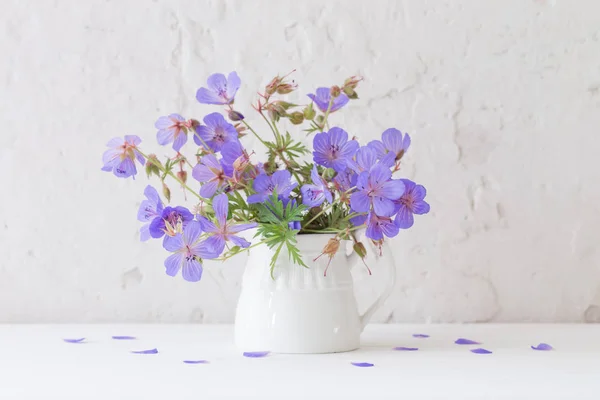 Flowers in jug on white background — Stock Photo, Image