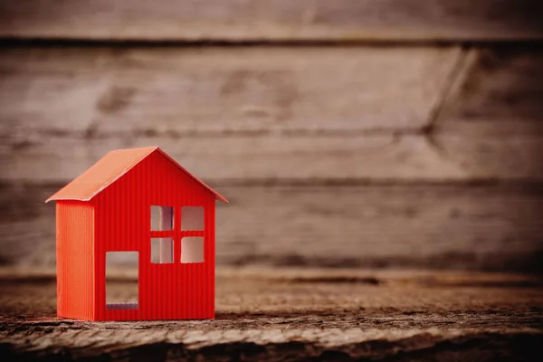 Бумажный дом на деревянном фоне — стоковое фото