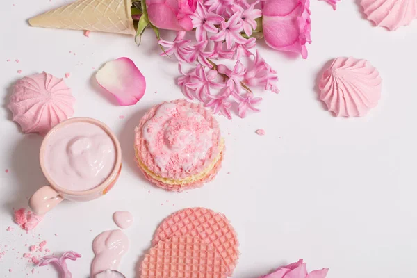 Fleurs dans un cône de gaufre avec yaourt et meringues sur le dos blanc — Photo