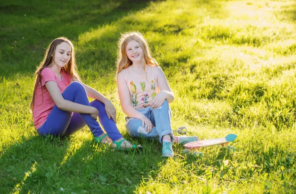 Chicas adolescentes con con monopatín en el parque de verano — Foto de Stock