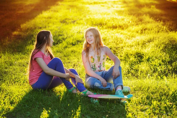 Chicas adolescentes con con monopatín en el parque de verano — Foto de Stock