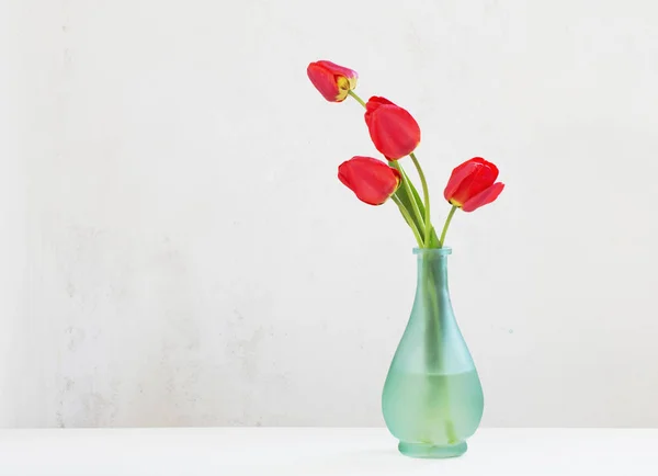 Rote Tupfen in der Vase auf weißem Hintergrund — Stockfoto