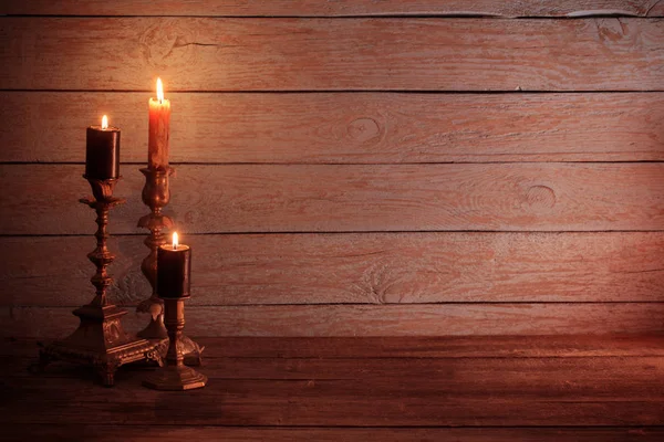 Burning  candles in vintage  candlestick on wooden background — Stock Photo, Image