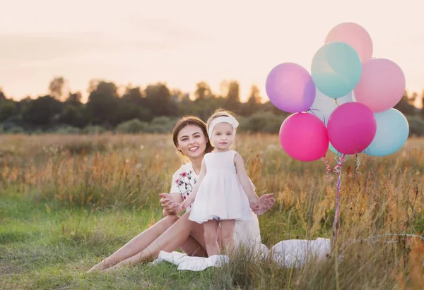 幸福的母亲和女儿用气球室外 — 图库照片