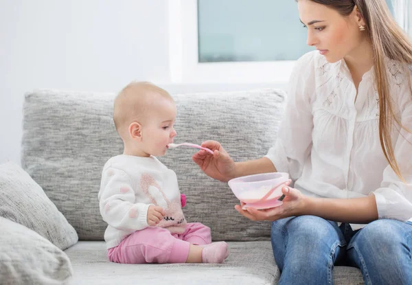 Mãe alimentando bebê interior — Fotografia de Stock