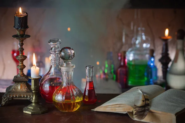 Potion magique, livres anciens et bougies sur fond sombre — Photo