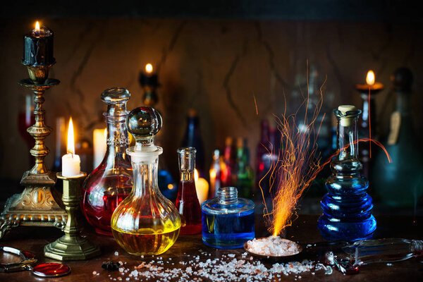 Волшебное зелье, древние книги и свечи на темном фоне
