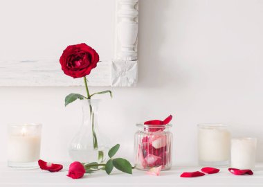 Gül vazo ve beyaz zemin üzerine mumlar