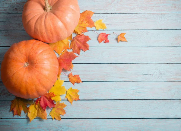 Autumn leaves and pumpkins on blue wooden background — Stock Photo, Image