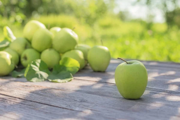 Manzanas verdes sobre fondo de madera al aire libre —  Fotos de Stock