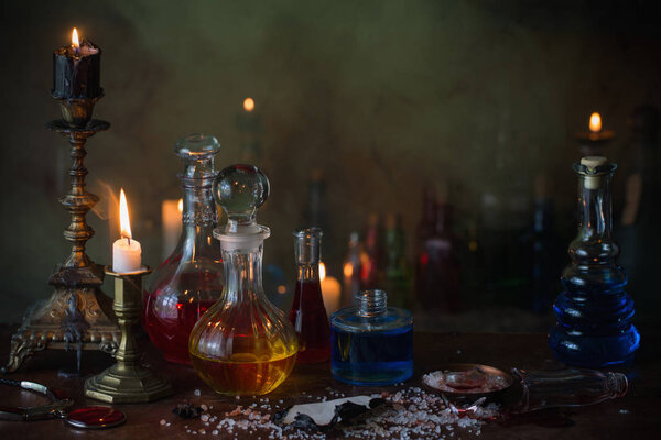 Волшебное зелье, древние книги и свечи на темном фоне
