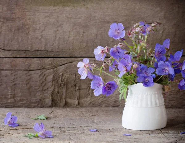 Eski ahşap zemin üzerine mavi çiçekler — Stok fotoğraf