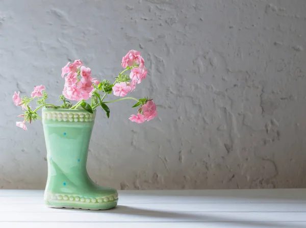Sommerblumen in Keramikstiefel auf weißem Hintergrund — Stockfoto