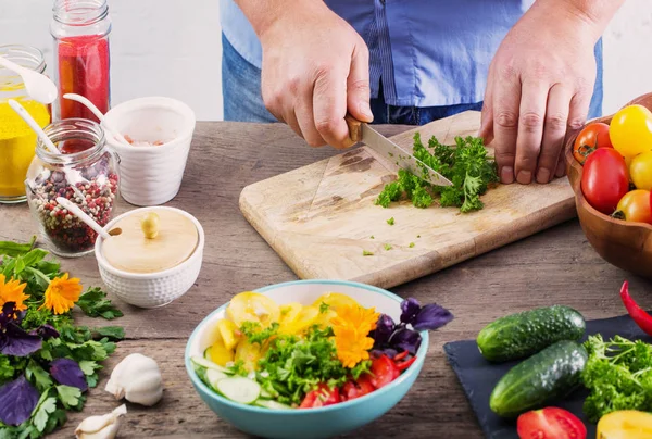 Uomo che cucina un'insalata vegetariana — Foto Stock