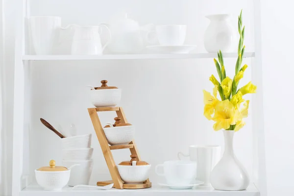 Vaisselle blanche avec des fleurs sur étagère en bois — Photo
