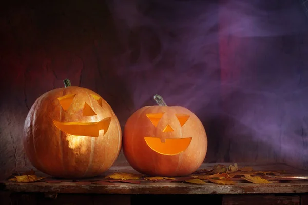 Halloweenpumpor på träbord på mörk bakgrund — Stockfoto