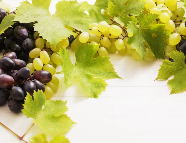 Winogrona na biały drewniany stół — Zdjęcie stockowe