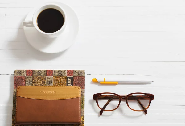 Gözlük, defter, kalem ve kahve Beyaz ahşap backgro üzerinde — Stok fotoğraf