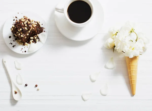 Bunga dalam kerucut wafel dan kue coklat di backg kayu putih — Stok Foto