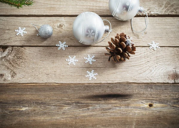 Weihnachtskugeln und Zapfen auf dunklem Holzhintergrund — Stockfoto