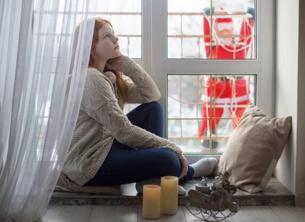 Chica en la ventana con santa claus — Foto de Stock