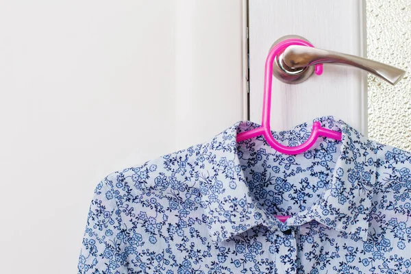 Блузка на вешалке на дверной ручке — стоковое фото