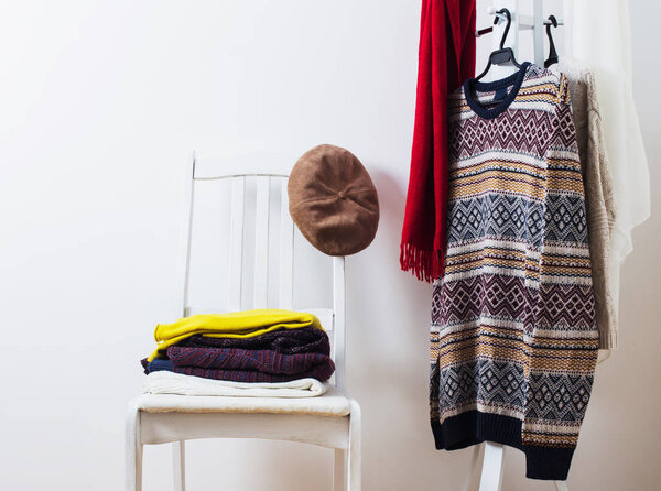 winter clothes on a chair against a white wall background