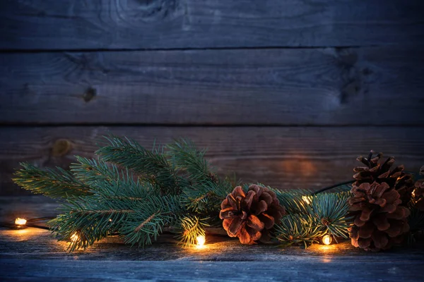 Різдвяні ялинові гілки з шишками і гірляндою — стокове фото