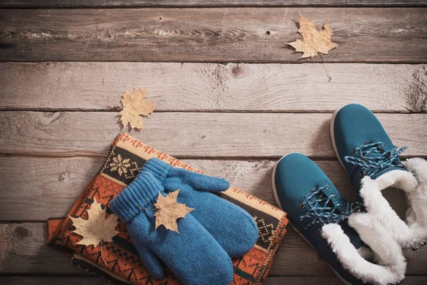 Zapatos de invierno, guantes, bufandas sobre fondo de madera viejo — Foto de Stock