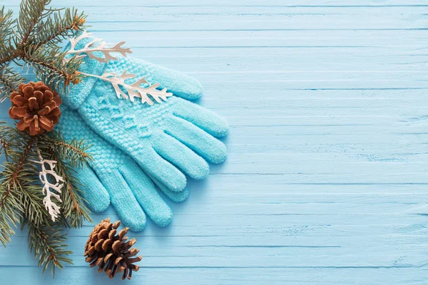 Blå handskar och jul fir på trä bakgrund — Stockfoto