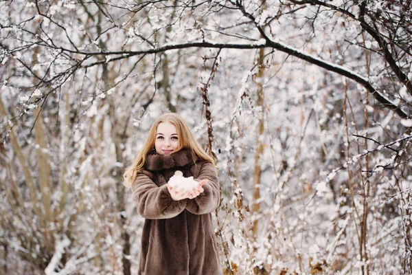 Улыбка девушки со снегом в руке — стоковое фото