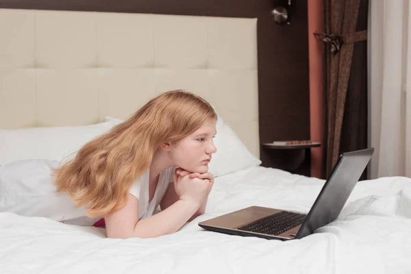 Het tiener meisje met laptop in bed — Stockfoto