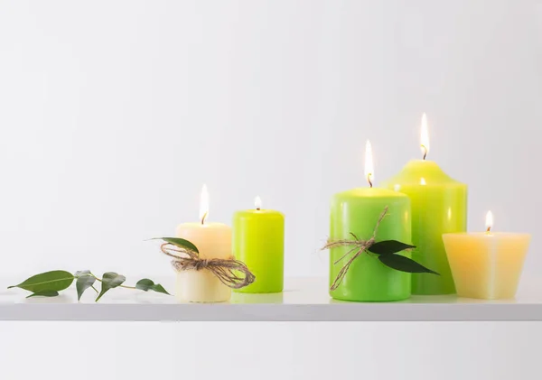 Зеленые горящие свечи на белом фоне — стоковое фото
